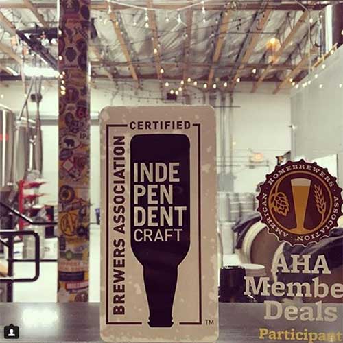 Certified Independent Craft sticker and sign on window with brewery kegs and fermenters