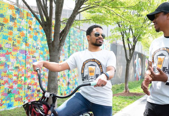 bikers enjoying the metropolitan beer trail in front of colorful mural